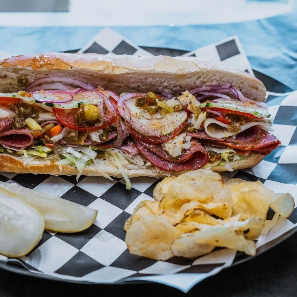 Italian sub with chips and a pickle