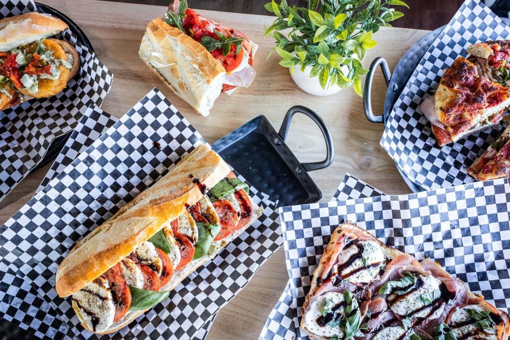 Subs and pizzettas on a table from above