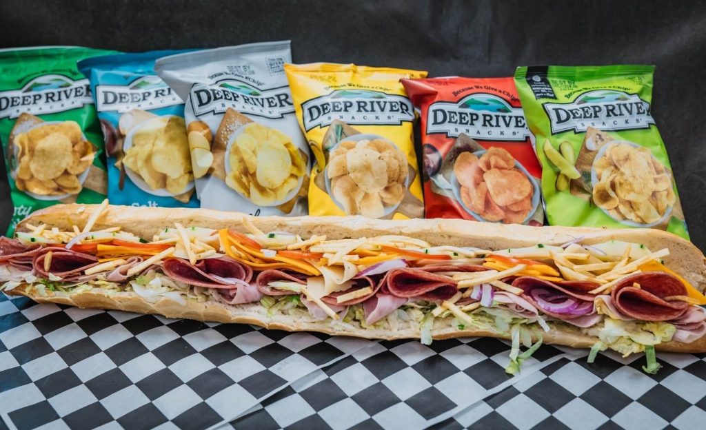 Italian sub in front of bags of chips